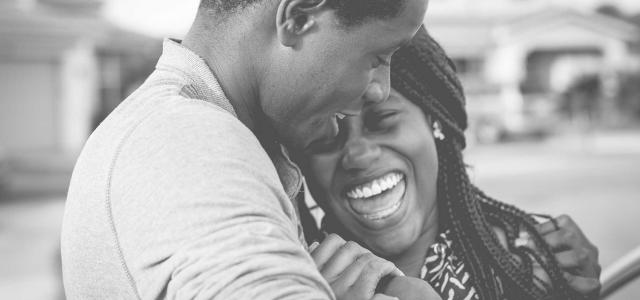 A black and white image of a couple laughing