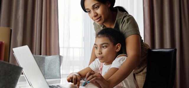 Mother and child working on a laptop together